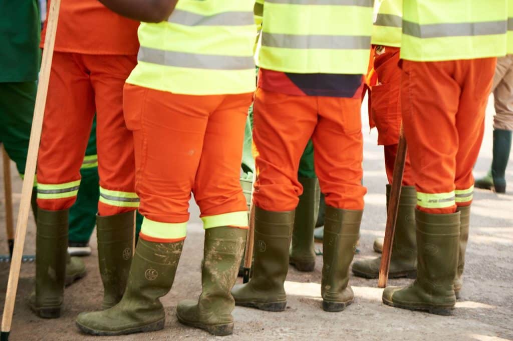 Grupo de operarios con ropa de alta visibilidad y botas de seguridad