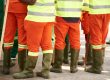 Grupo de operarios con ropa de alta visibilidad y botas de seguridad