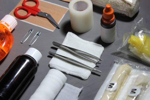 Material de primeros auxilios de un botiquin de empresa: gasas, vendas, pinzas y tijeras
